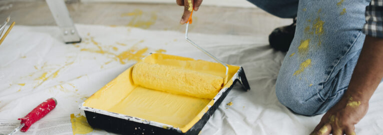 Man painting the walls yellow